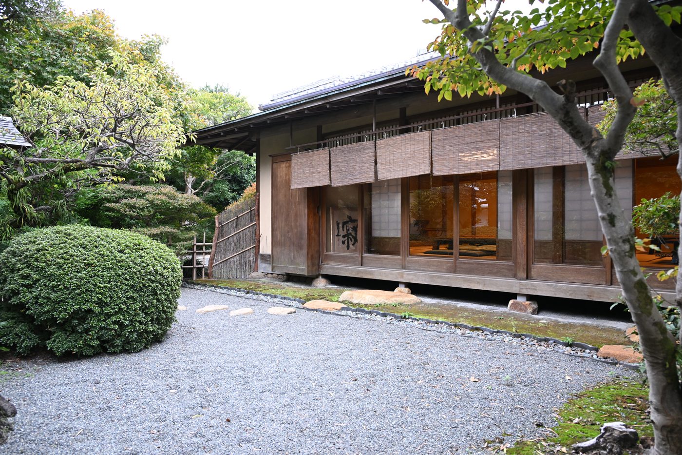 A traditional wooden tea hall with reed blinds and a gravel garden at the foot of Mt. Fuji